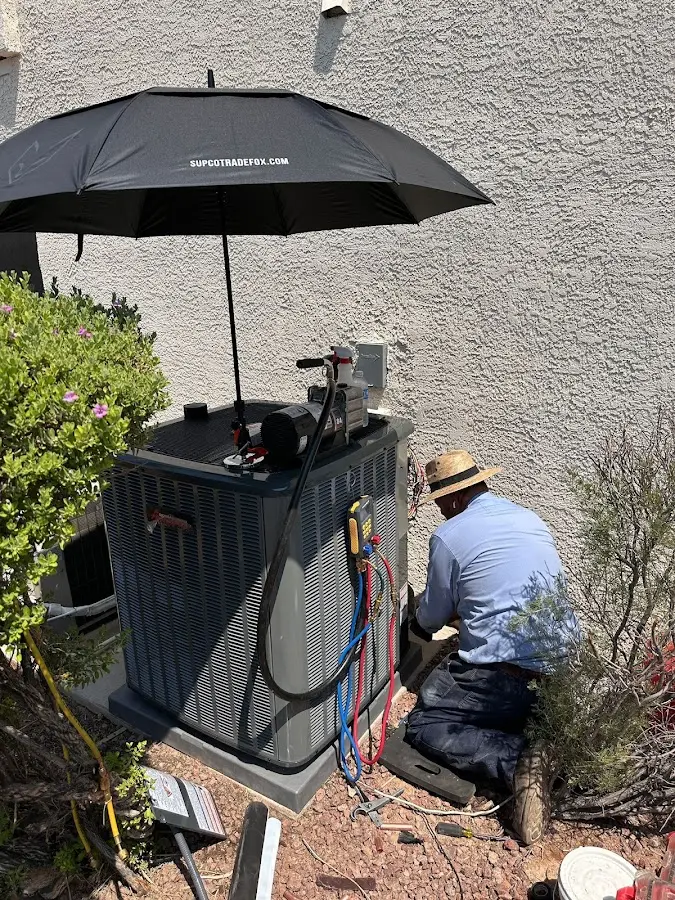HVAC technician performing outdoor AC maintenance in Eaton
