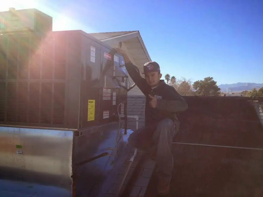 HVAC technician performing Heat Pump Repair on a rooftop unit in Eaton